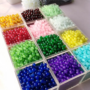 Macro shot of 4mm to 8mm colorful glass beads in a divided clear organizer tray