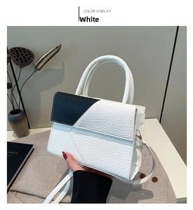 Détail de la texture cuir croco blanc avec contraste noir sur le sac à main
