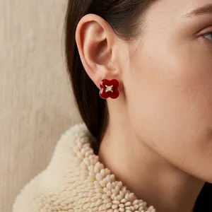 Vintage red flower stud earrings with gold plating and zircon center on female model