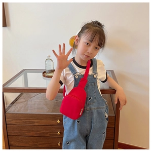 Toddler girl wearing a bright red nylon crossbody chest bag with silver zipper detail