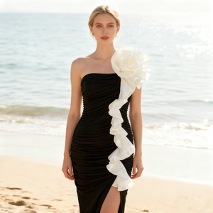 Detail of 3D white floral decoration and ruffles on a black strapless mermaid dress