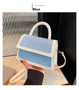 Detailed view of sky blue and cream white color-blocking handbag with gold hardware