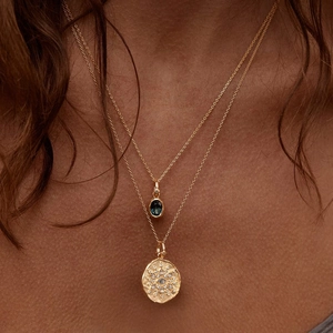 Ins-style 12 birthstone necklaces with dark oval gem and round relief pendant on a model