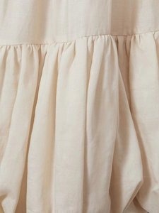 Detailed macro shot of pleated beige cotton-linen fabric texture with subtle craftsmanship