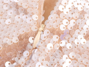 Détail d'une fermeture éclair invisible sur tissu à paillettes champagne de robe
