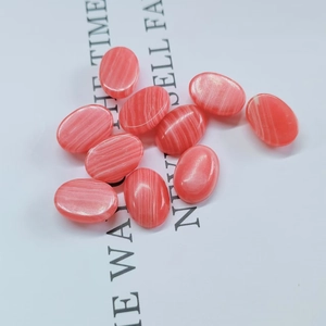 Flat back oval pink striped agate cabochons for DIY jewelry making scattered on paper