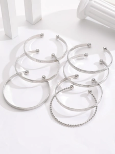 Detailed macro view of 7-piece silver alloy cuff bracelets with various textures and stars