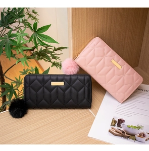 Detail of PU leather long wallets with diamond stitching, gold trim and furry pompom charms