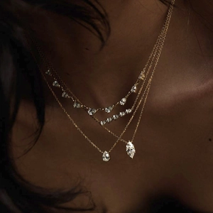 Three-layer gold necklace with round pear and marquise-cut zircon pendants on model