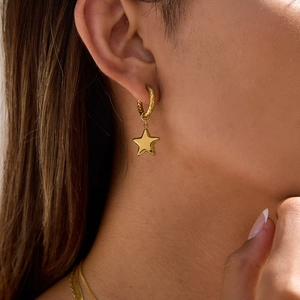 Detailed close-up of 18K gold stainless steel star and pearl earring on a model