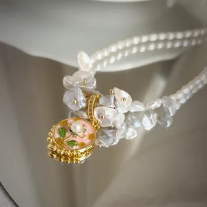 Macro shot of freshwater pearl necklace with floral enamel pendant and mirror reflection