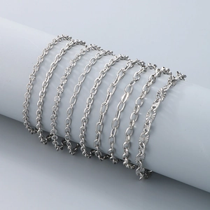 Detail view of various silver metal link chains displayed on a gray cylinder stand