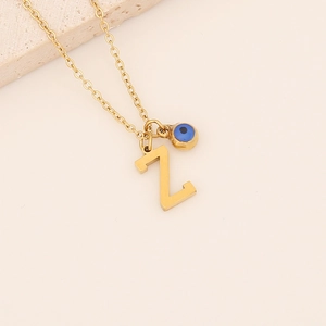 Gros plan détaillé du pendentif lettre Z doré avec perle œil bleu en acier inoxydable