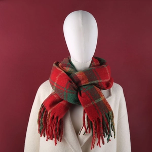Detail of red and green plaid scarf with soft fringe and thick warm knit texture