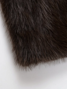 Close-up detail of dark brown faux fur vest showing soft texture and fluffy long pile fibers