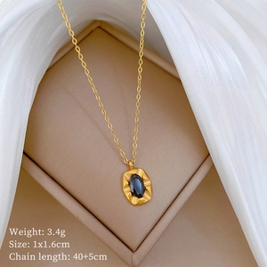 Macro detail of gold-plated titanium steel necklace with an oval black gemstone pendant