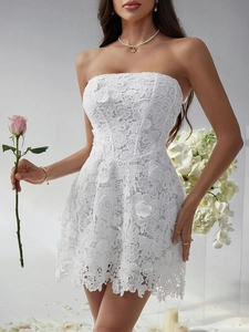 Close-up of white lace strapless dress showing delicate floral texture and slim fit
