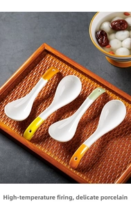 Detail of four ceramic soup spoons with colorful handles on a woven wooden tray