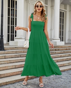 Detail of green layered summer maxi dress with pleated bodice and ribbon straps outdoors