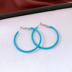 Detail view of turquoise blue 14K gold plated hoop earrings with smooth glossy finish