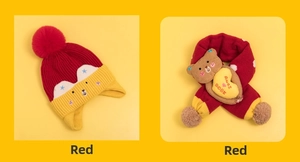 Detail of red and yellow knit hat and scarf set with cute plush bear and heart embroidery