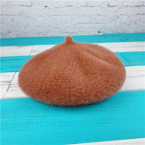 Detailed close-up of the brown faux rabbit fur beret showing plush texture and top tab