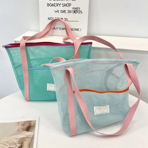 Détail du sac de plage en maille colorée avec bordure contrastée et poche avant