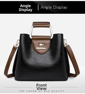 Detail of metal kangaroo logo and textured PU leather on a black and brown tote bag