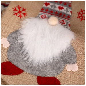 Détail macro du gnome décoratif sur une chaussette de Noël en toile de jute rouge