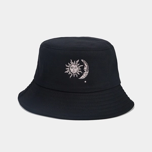 Detail of sun and moon embroidery on a black bucket hat with vintage mystic style