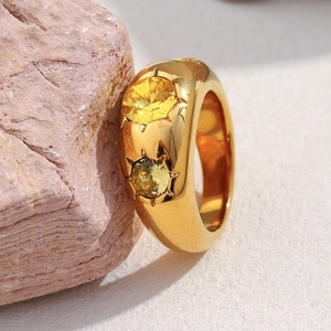 Detail showing gold chunky dome ring with two yellow zircons on textured red rock