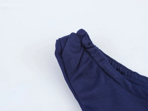 Détail de la texture du tissu bleu foncé et des nœuds cousus d'une robe sans manches