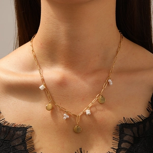 Collier trombone doré en acier inoxydable avec pendentifs coquillages et perles sur un mannequin