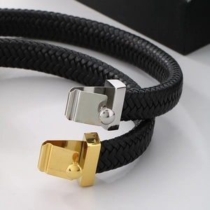 Macro shot of double-layer black braided leather bracelet with gold and silver metal buckles