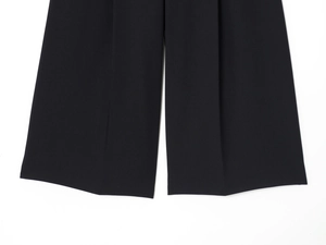 Gros plan détaillé montrant le tissu lisse et l'ourlet du pantalon large noir élégant