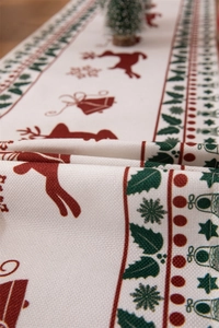 Close-up of woven cotton-linen Christmas table runner with reindeer and holly patterns