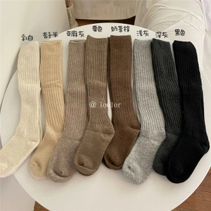 Flat lay of ruffle trim knit crew socks in eight neutral colors on a minimal background