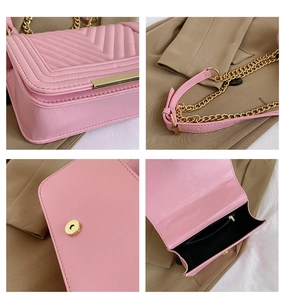 Detail view of pink quilted crossbody bag showing V-pattern, chain strap and inner pockets