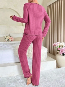 Detail of rose red ribbed pajama set with elegant black lettuce edge trim on the back
