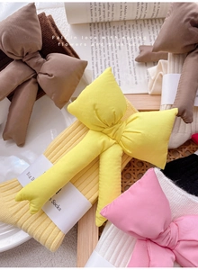Detail of colorful knitted socks with detachable 3D stuffed bows in pastel colors