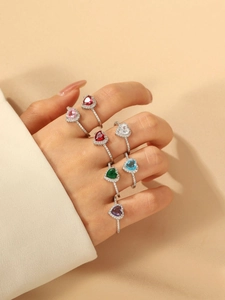 Detail of silver heart-shaped gemstone rings in multiple colors with zircon inlay