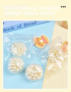 Detail of squeezing stress toy bag with white pearls and shell tag on blue background