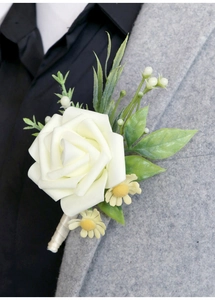 Detail of a white rose and yellow daisy boutonniere on a gray suit lapel for weddings
