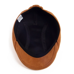 Detail view of the soft brown suede beret featuring black inner lining and washing label