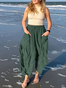 Detail of dark green cotton linen pants featuring elastic waist and large side pockets