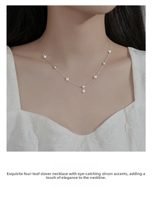 Detail of s925 silver four-leaf clover necklace with cubic zirconia on female collarbone