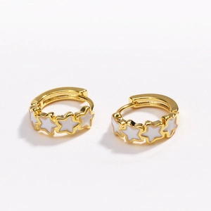 Detail of gold hoop earrings featuring white enamel stars on a clean white background