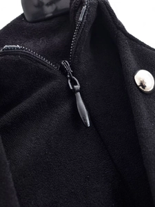 Detail view of the silver metal button and high-quality zipper on black flared pants