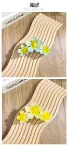 Detail von bunten Frangipani-Haarklammern mit matter Harztextur und dreifachem Blumendesign