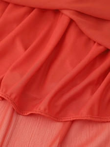 Macro detail of red mesh fabric with pleated chiffon layers and delicate rolled hem